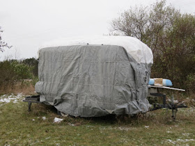 small trailer covered for the winter