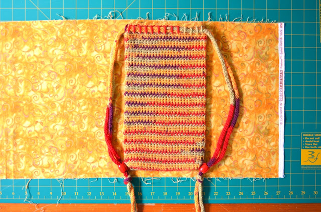 fabric laid out on cutting mat with bag laid on top.