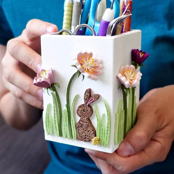 white quilling tool holder decorated with quilled flowers and rabbit