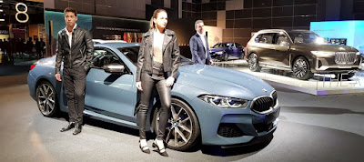 Models pose next to The 8 by BMW, with Wehner in the background.