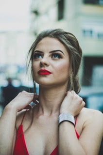 Woman wearing red lipstick and dress after lip filler treatment.