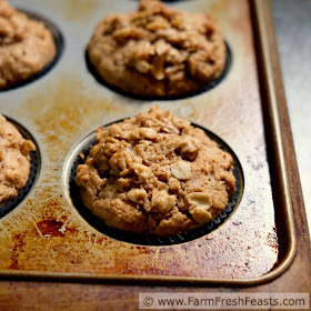 a close up image of a whole wheat pear and pecan streusel-topped muffin in a pan