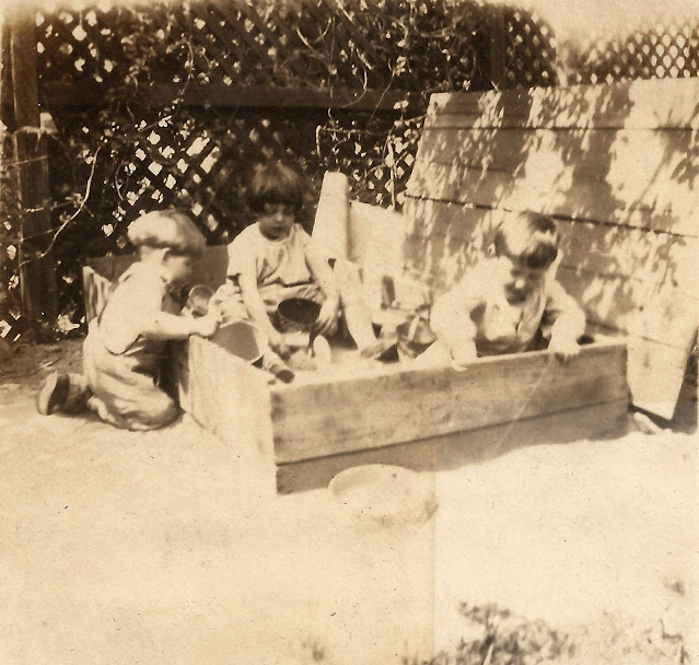 Charles, Catherine and David Wright playing in a sandbox, 1925