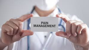 "A person sits in a calm environment, receiving supportive care for pain management. They are surrounded by comforting items, including a soft pillow and blanket, symbolizing personalized strategies for relief and well-being."