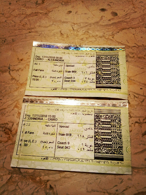 Cairo to Alexandria by train. Tickets are purchased in the station, fellow passenger helped me to translate but would work fine by pointing at the train number, destination and time on the schedule. Tickets are printed in both English and Arabic