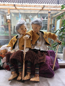 two puppets identically dressed sitting side by side by a window. Reflection puppet project by Corina Duyn