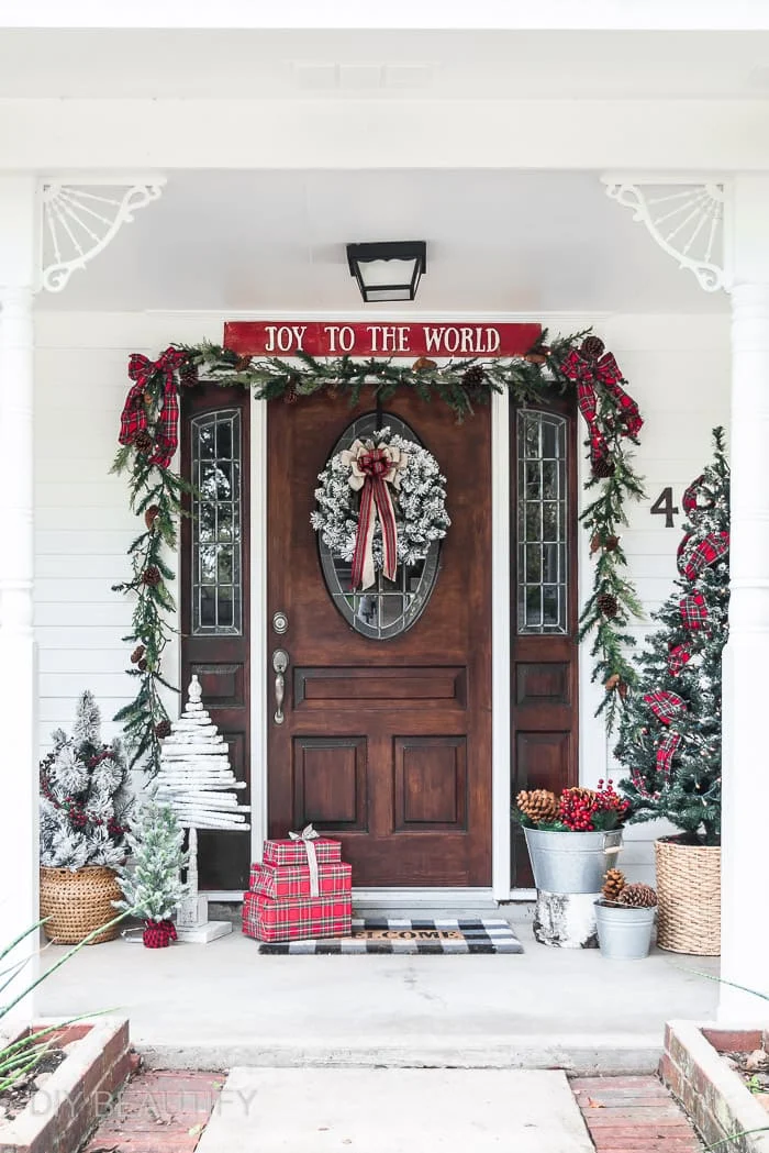 Christmas front door with Joy to the World sign, garland, red plaid and Christmas trees