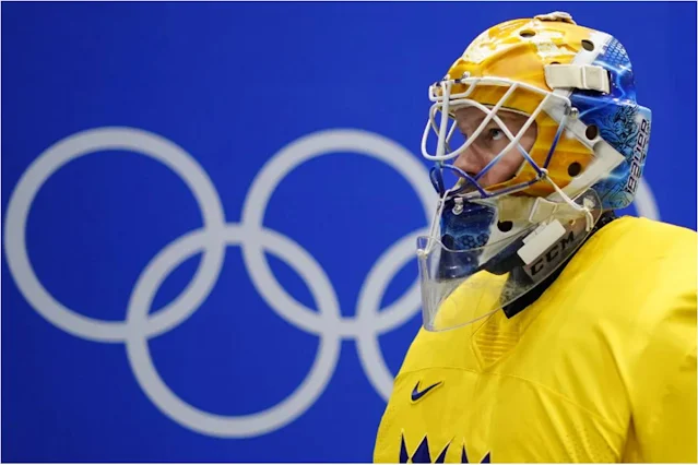 Jogador de Hóquei no Gelo da Suécia, com painel com os arcos olímpicos ao fundo