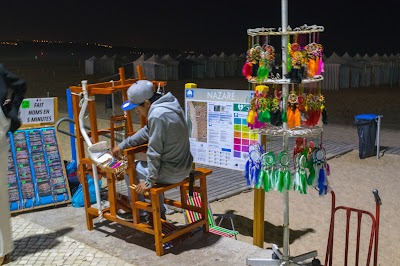 A man crafting souvenirs at night by the beach