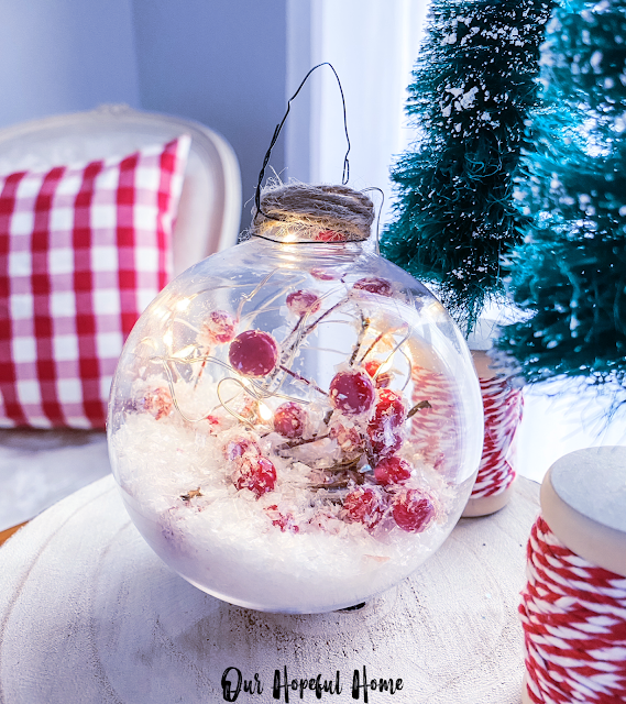 clear globe ornament filled with faux berries and snow