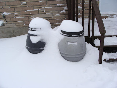 Compost bins half buried in snow