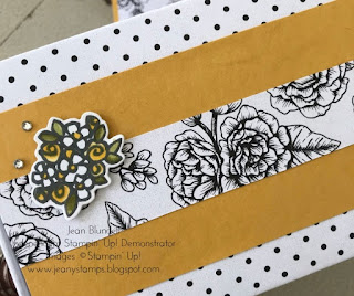 A wrapped giftbox using black and white polka dot paper with a strip of Bumblebee yellow cardstock attached, then balck and white florals on top of that. Finishing decorations are a small handstamped and coloured bunch of roses and daisies and some small rhinsteone jewels.