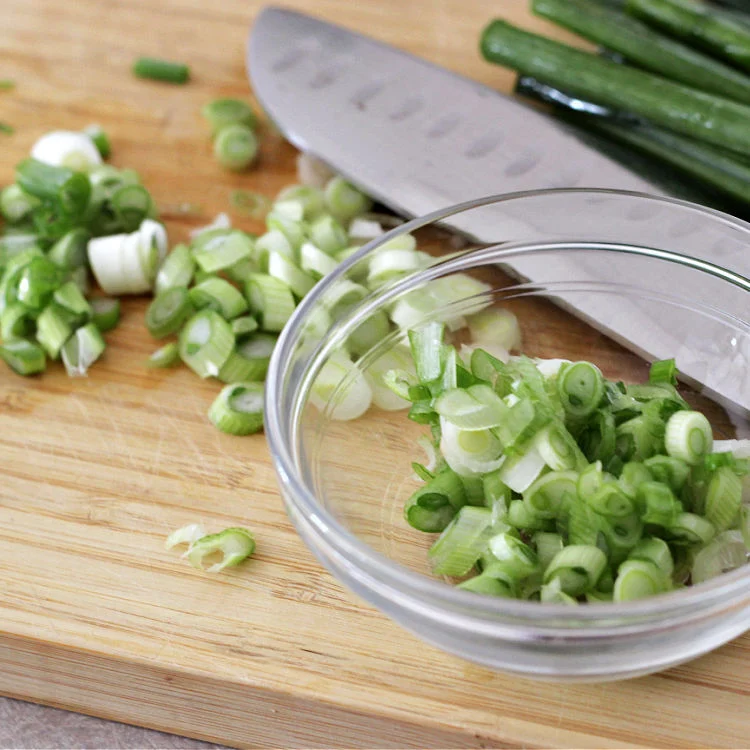 Chopped green onions for quick and easy pork and cabbage stir fry bowls