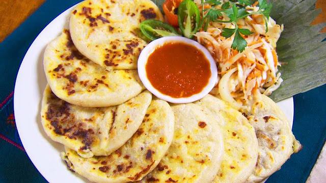 Savory pupusas served on a plate with a side of zesty curtido and flavorful salsa, a mouthwatering Salvadoran delight.
