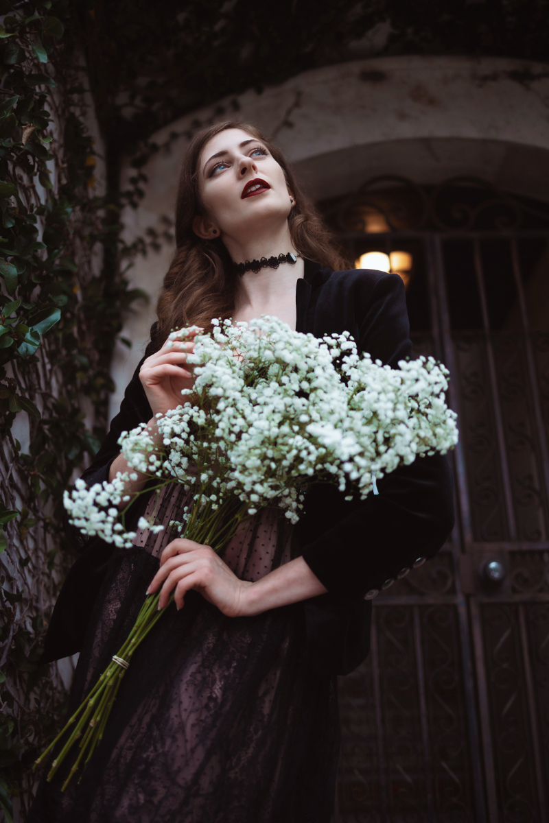 an aesthetic portrait of a young woman with a bouquet of  white flowers in her hands