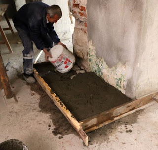 A bucket of concrete is added to the step