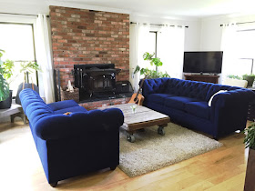 royal blue tufted sofa sectional pottery barn farm house living room decor reclaimed pallet coffee table with industrial casters wood burning stove house plants natural light little flower soap co