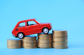 A toy car driving over coins