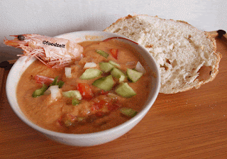 Gazpacho, cold Spanish veggie soup in a bowl with a shrip and a half a bun of bread