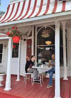 Sitting on the porch of Miss Nelle's Bakery and Cafe, Baysville, Ontario, Canada