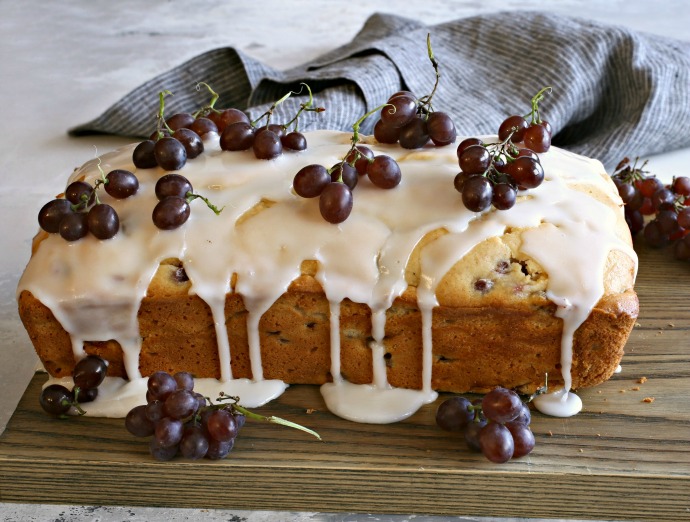 Recipe for a loaf cake baked with champagne grapes and topped with a lemon glaze.