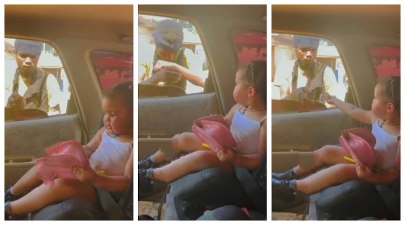 Cute baby Girl goes viral as she opens handbag and gives a beggar money through window (Video)