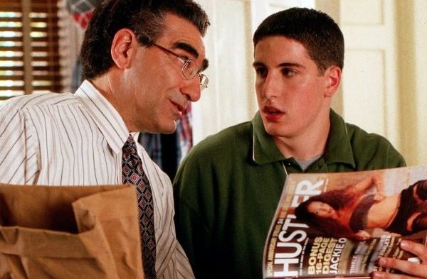 Film still from American Pie. A father and son sitting next to one another. The son is looking at a porno magazine.