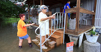 Hayley Hebert (left), Clara Cohorn (center) and Lisa Earnest walk to Cohorn's home after she was evacuated Tuesday due to rising water after recent rain in Abbeville, La. (Photo Credit: AP Images Click to Enlarge.