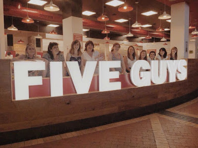 five-guys-lighted-sign-with-people-stood-behind