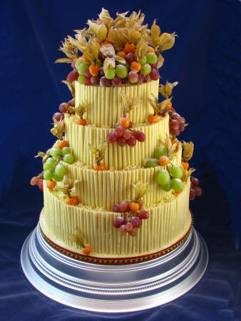 Elegant round four tier chocolate curl wedding cake with raspberries