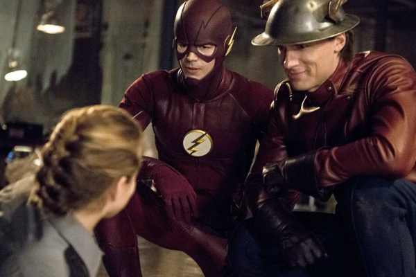 Grant Gustin and Teddy Sears as the Earth-One and Earth-Two Flashes crouching by Shantel VanSanten as the injured Patty Spivot