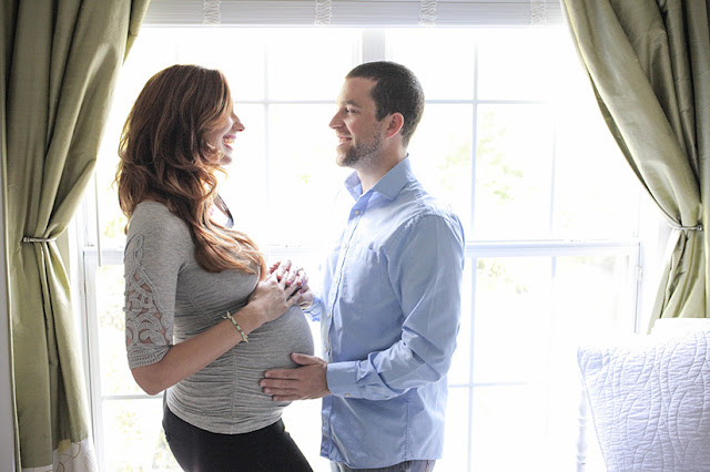 Amy West and husband sharing a moment during 35 week maternity shoot