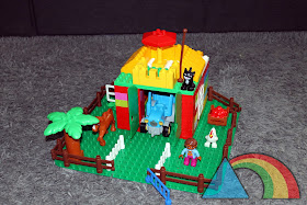 Casa construida con piezas de Lego Duplo sobre base verde