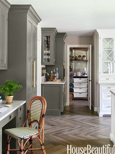 traditional kitchen with soft brown beige hard wood floors in chevron pattern gray painted and white glass front cabinets