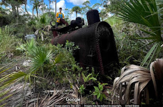 Photo of steam engine abandoned in woods.