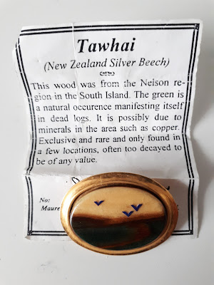 New Zealand Tawhai brooch attached to a paper explaining how it was made.