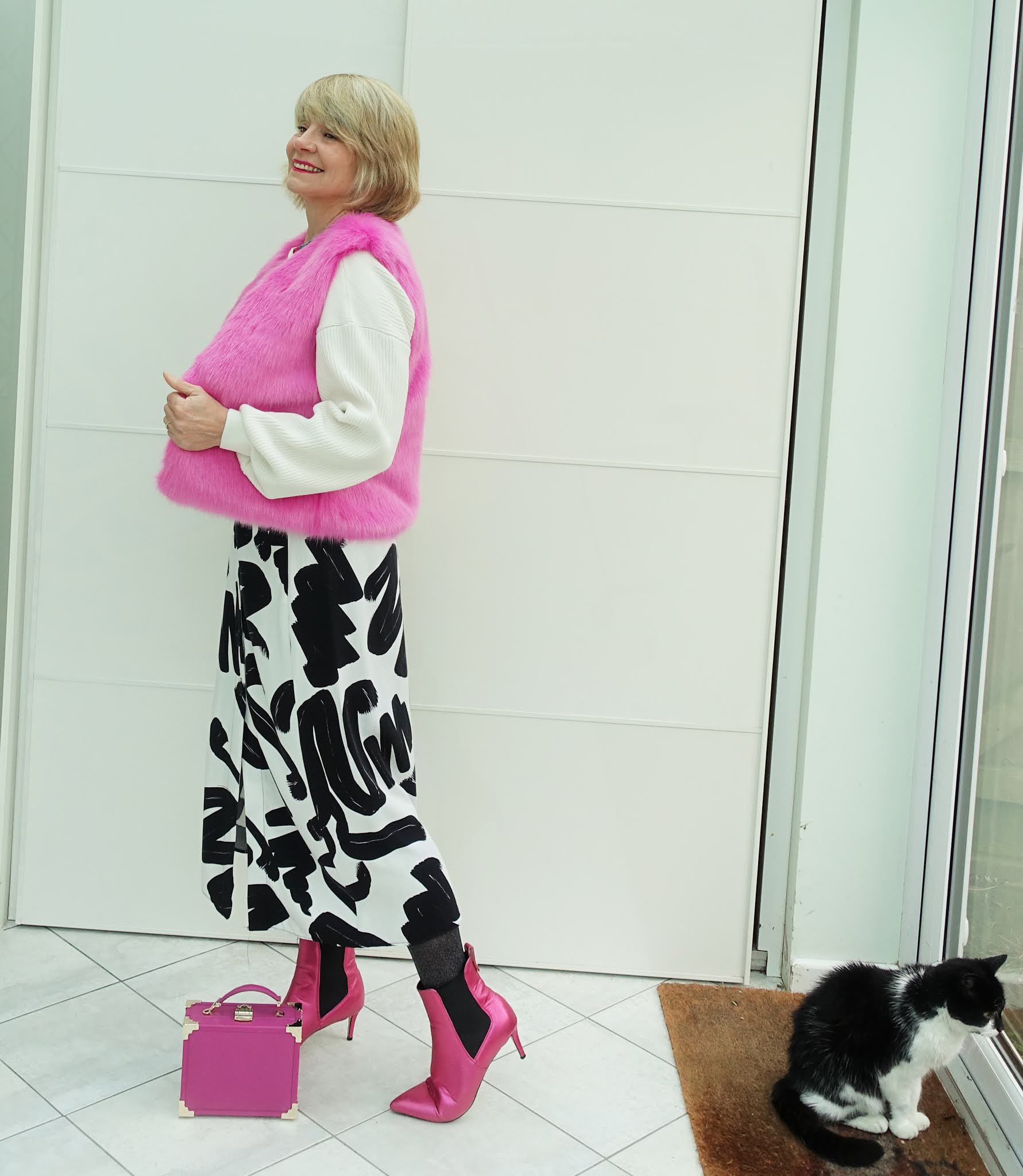 A faux fur pink gilet and pink boots liven up a black and white skirt and white top as Is This Mutton explores the different names for garments used in the UK and US