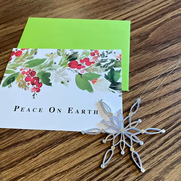 Peace on Earth Christmas card and quilled snowflake ornament displayed on table