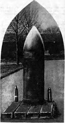Снаряд 42-сантиметровой пушки, упавший на одно из передовых укреплений Вердена. Снаряд не разорвался. Рядом с ним для сравнения поставлены снаряды французской 75-миллиметровой и германской 77-миллиметровой пушек. Снаряды стоят на фоне строений артиллерийского склада.