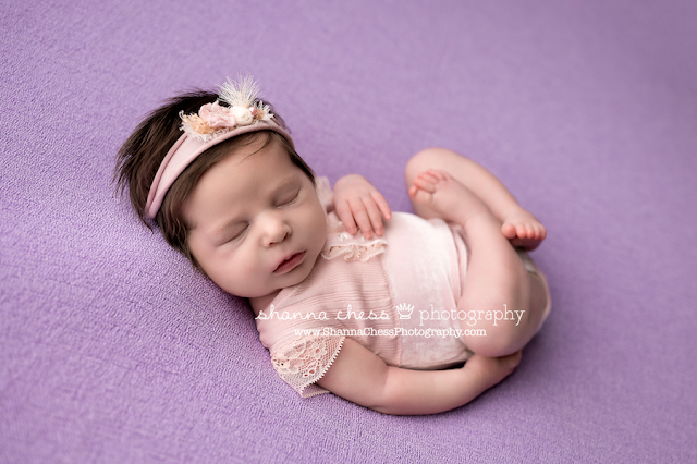 Newborn photo studio Eugene Oregon, baby girl asleep on purple beanbag