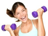 happy and smiling woman lifting dumbbells