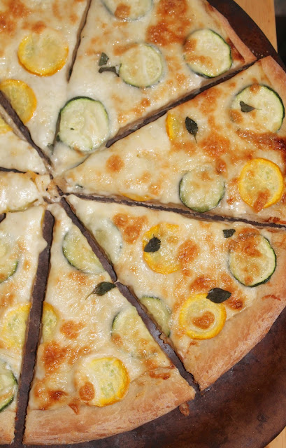 Zucchini garlic alfredo pizza on a pizza stone.