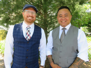 Two men wearing vests and neckties.