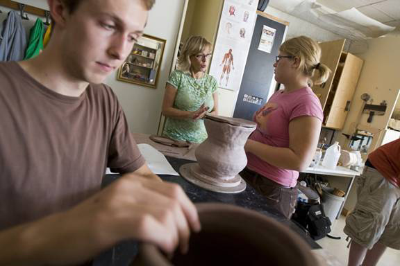 Susanne Kilpela assists students in her ceramics class at Michigan Tech