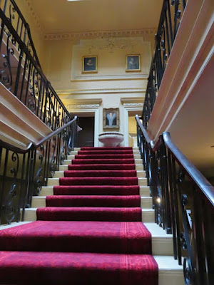 staircase with red carpet and wrought iron railing