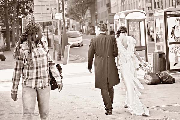 a person on the street looking at bride and groom walking by at kings cross wedding