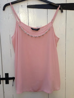 a baby pink cami top with gem detailing around the neckline