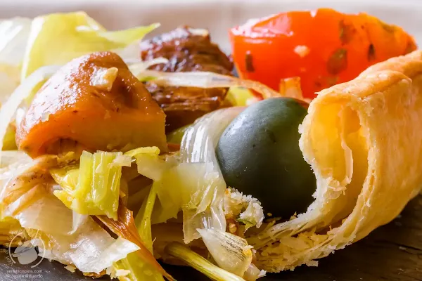 Hojaldre de puerros con níscalos, tomate y aceitunas