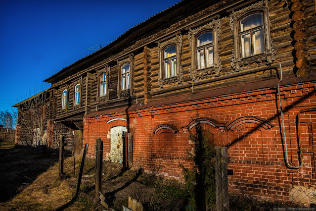 Стена полукаменного дома в лучах закатного солнца