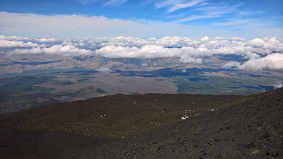 Clouds, lava and views from Mount Etna main crater.